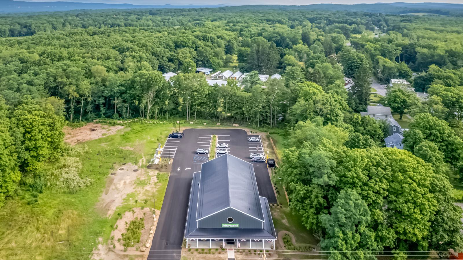 Aerial view of the Farmers Choice New Paltz barn surrounded by summer green Hudson Valley woods