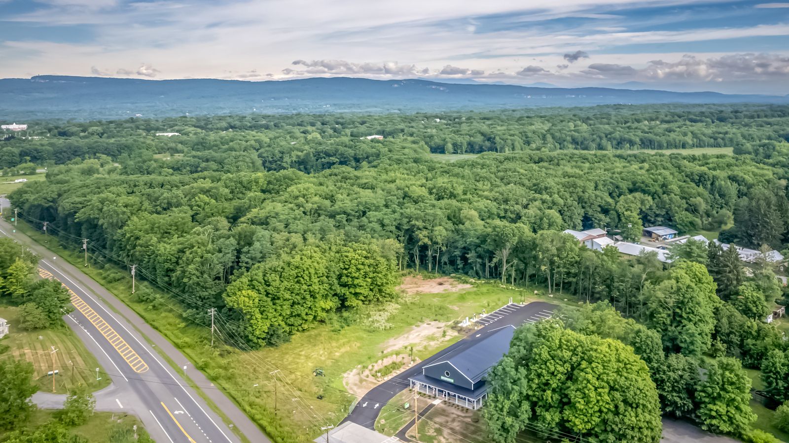 Aerial view over Route 299 in New Paltz with the Shawangunk Ridge on the horizon and the Farmers Choice barn below